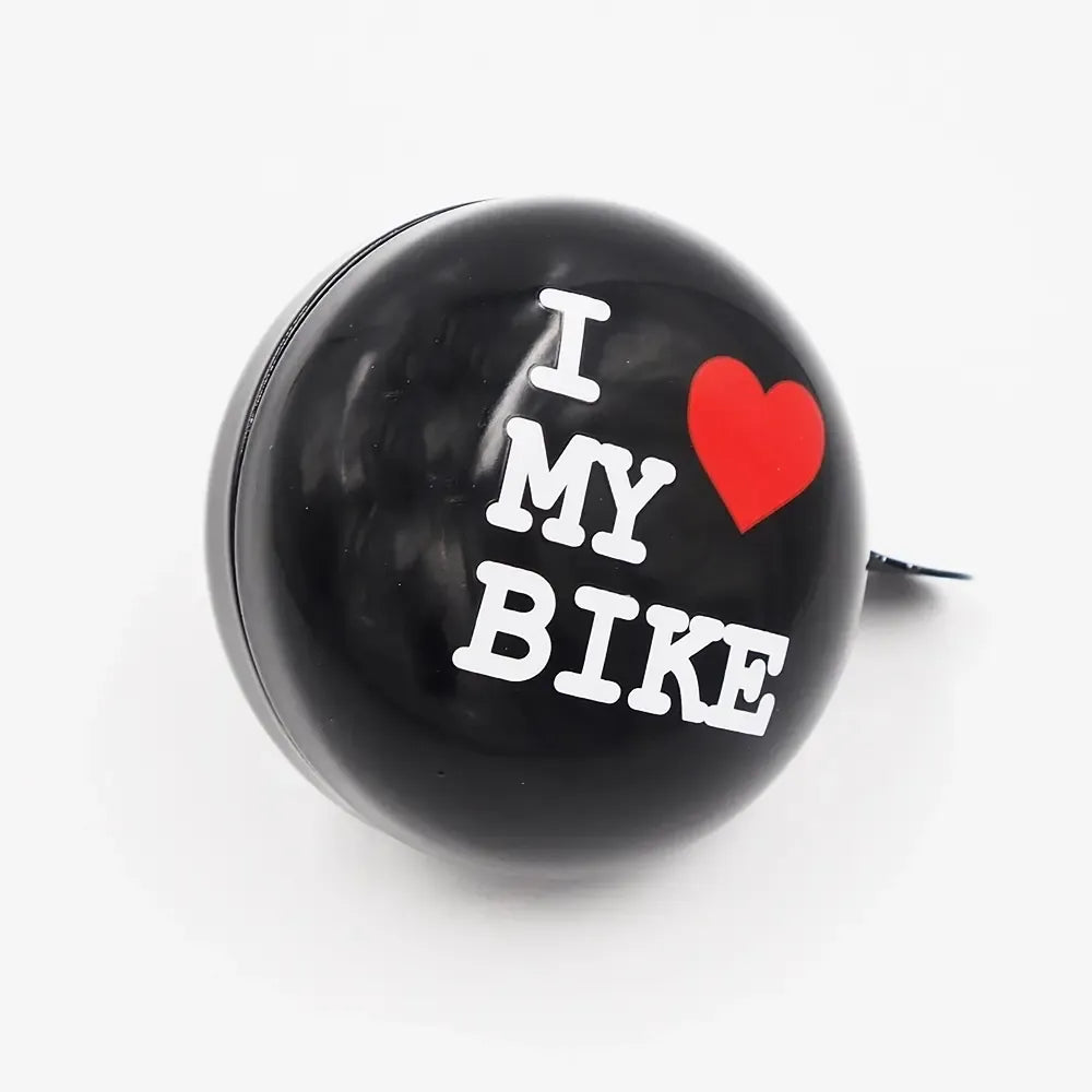 Dviračio skambutis „I love my bike“, juodas su raudonu užrašu, tinka dviračiui ir suteikia garsą bei stilių.