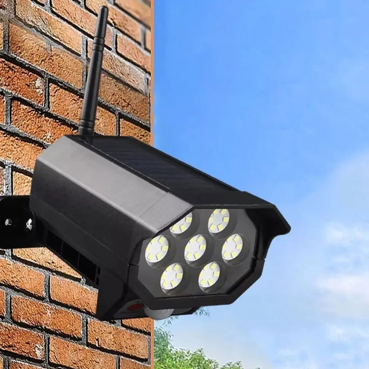 Kameros imitacija su LED šviestuvu ir judesio jutikliu, tvirtinama prie sienos, naudinga apsaugai ir apšvietimui lauke.