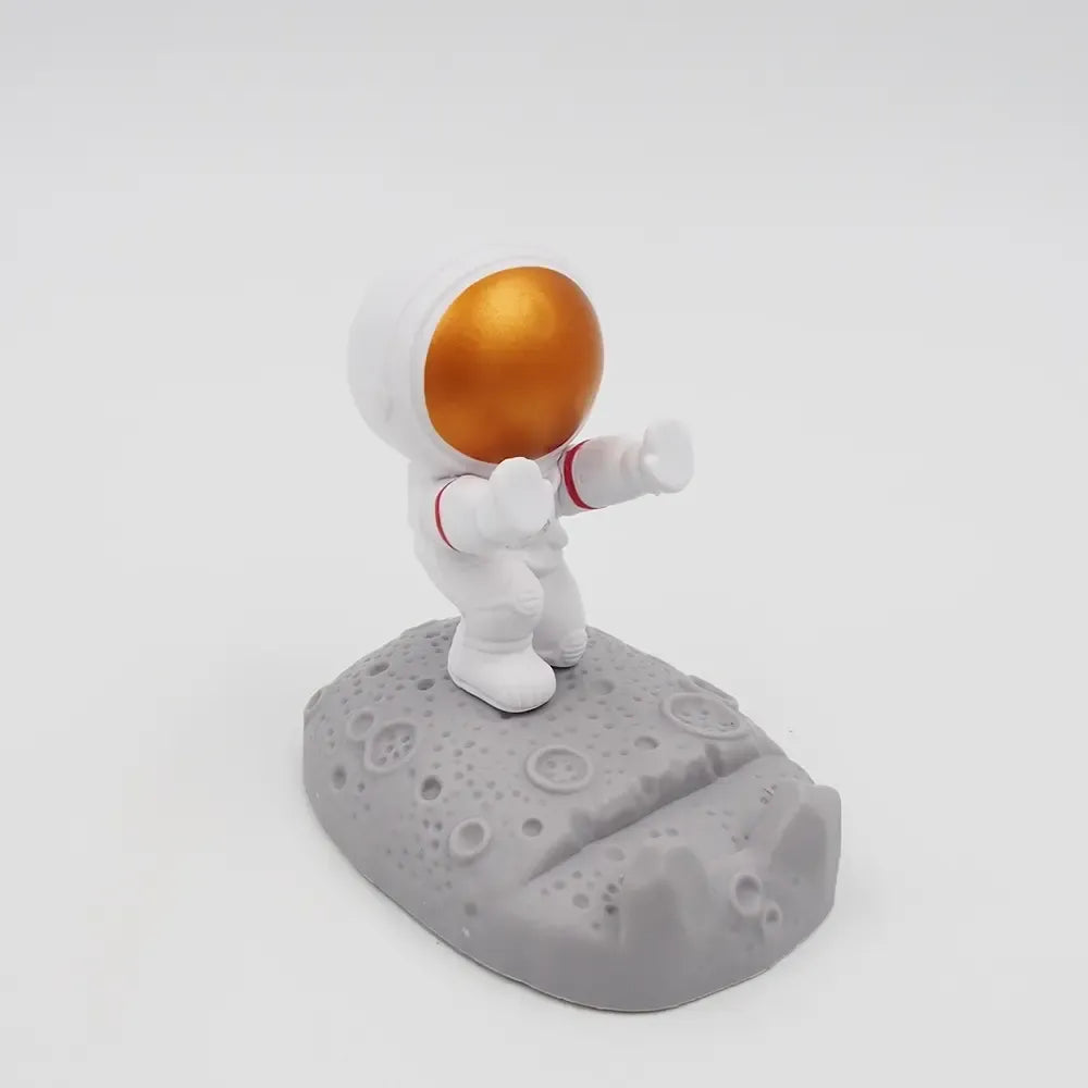 Amžinas telefono stovelis „Astronautas“, pagamintas iš tvirto plastiko, su astronauto motyvu, tinkamas naudoti namuose ar biure
