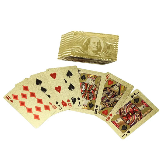 Auksinės kortos su 100 dolerių dizaino, žaidimų kaladė, blizganti aukso spalva ir detalus raštas, skirta žaidimams ar kolekcijai.