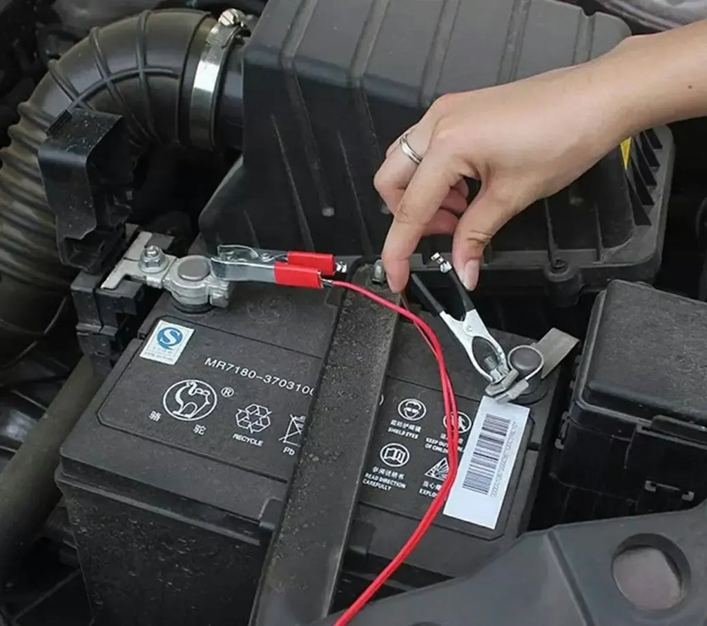 Automobilinis 12V cigarečių degiklio lizdas su krokodiliniais laidais, dažniausiai naudojamas automobilių elektros jungtims.