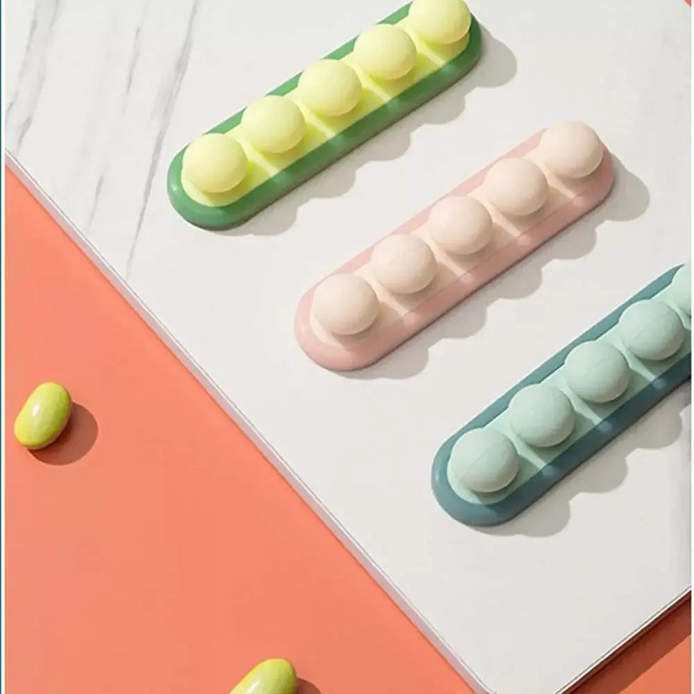 Laidų laikiklis Beans, plastikinis organizatorius laidų tvarkymui, baltos spalvos, su lipnia juosta, patogus tvarkingumui.