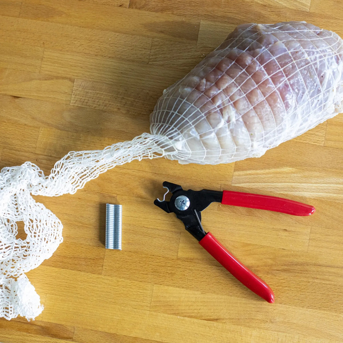 Mėsos spaustukų replės, profesionalus įrankis dešroms ir mėsos gaminiams, su tvirtomis rankenomis ir ilgomis žnyplėmis.