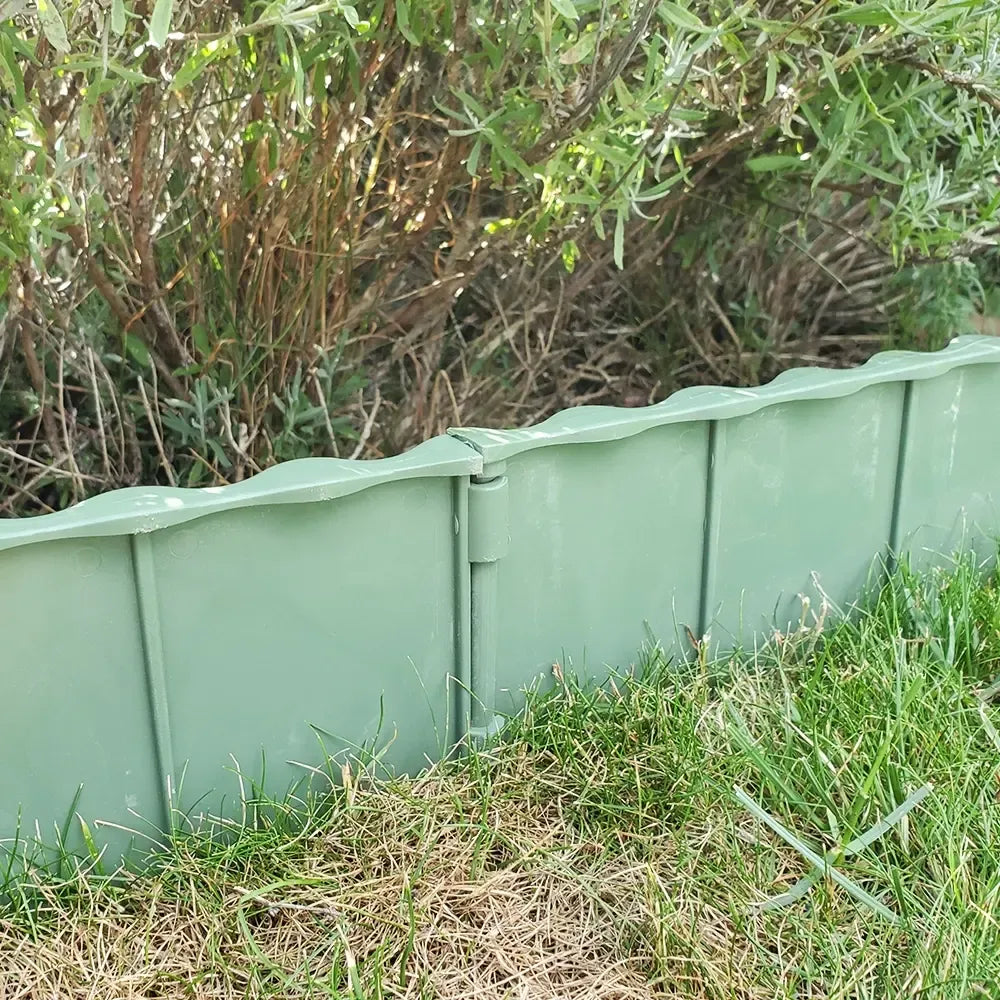 Žalios plastikinės vejos atitvaros, 5 vnt. rinkinys, matomos išlenktos atitvarų dalys, skirtos žolei ir takams atskirti.