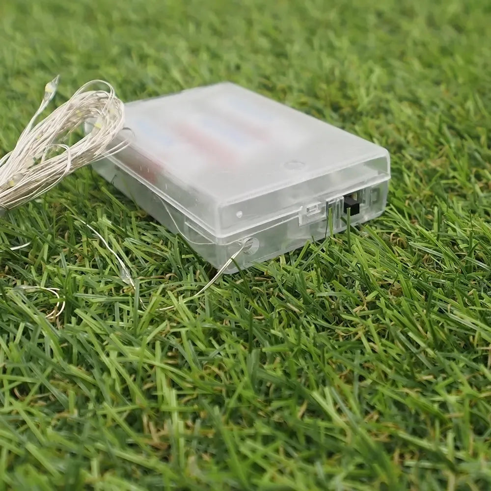 Šaltai balta LED girlianda su 50 LED, 5 m ilgio, veikianti su AA baterijas, dekoratyvi apšvietimo priemonė.