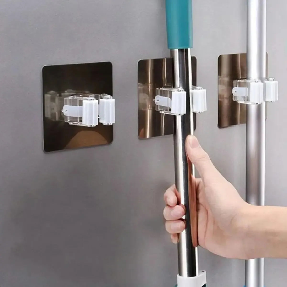 Sieninė pakaba sodo įrankiams ir šluotoms, metalinė su keliais kabliukais, tvirtinama prie sienos ir naudinga organizacijai.
