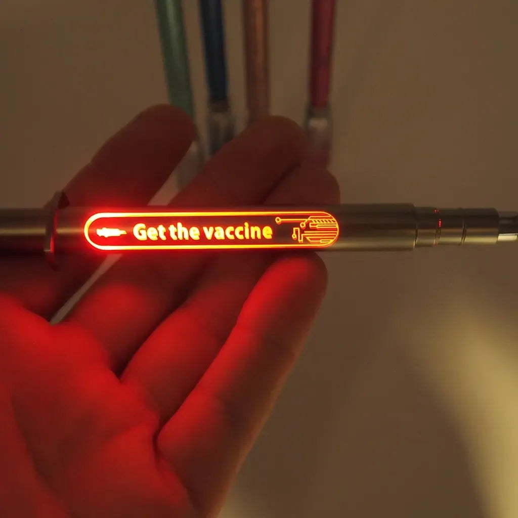Šviečiantis rašiklis su LED apšvietimu „Get the vaccine“, baltas su raudonom ir mėlynom detalėm, galimybė rašyti ir šviesti.