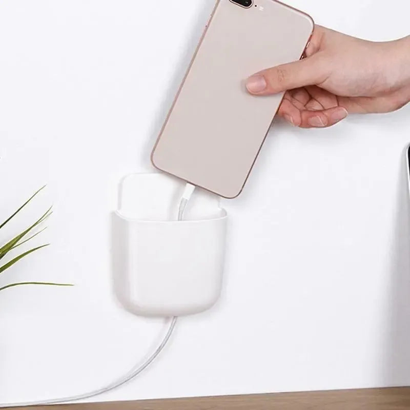 Universalus sieninis telefono laikiklis įkrovimui, tvirtinamas prie sienos, su vieta telefonui ir įkrovimo laidui.